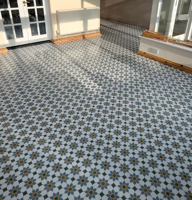 Blue and white patterned encaustic style floor tiles across a large room