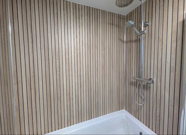 Wood effect wall panels in a shower over a white bath