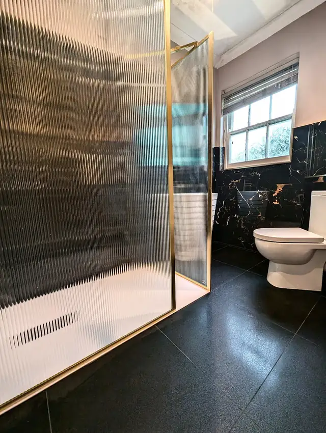 Fluted glass walk in shower with brass frame