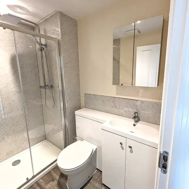 White shower room with grey marble effect walls and vanity